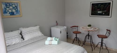 a bedroom with a bed and a table and chairs at Pousada Ruby in Irati