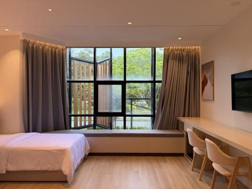 a bedroom with a bed and a large window at Goldlight Inn in Miri