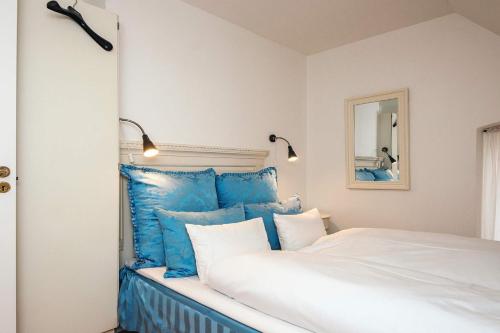 a bedroom with a white bed with blue pillows at 4 star holiday home in Skanderborg in Skanderborg