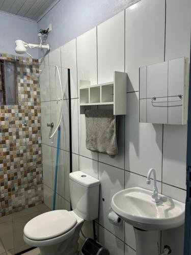 a bathroom with a toilet and a sink at Cantinho do Descanso in Cascavel