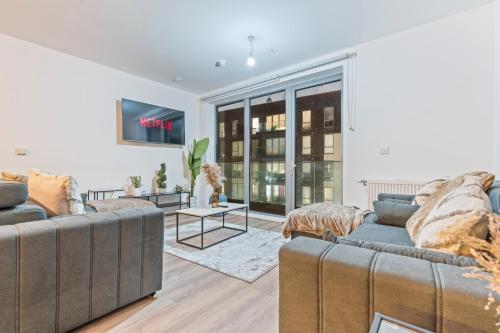 a living room with two couches and a tv at Luxury Highrise Flat Wembley Stadium & Event Stay in London