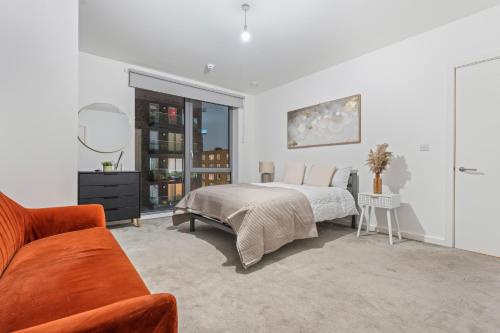 a white bedroom with a bed and a couch at Luxury Highrise Flat Wembley Stadium & Event Stay in London
