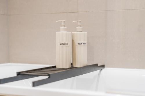 two bottles ofodorizers sitting on a shelf in a bathroom at Luxury Highrise Flat Wembley Stadium & Event Stay in London