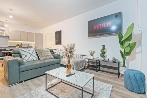 a living room with a couch and a tv on the wall at Luxury Highrise Flat Wembley Stadium & Event Stay in London