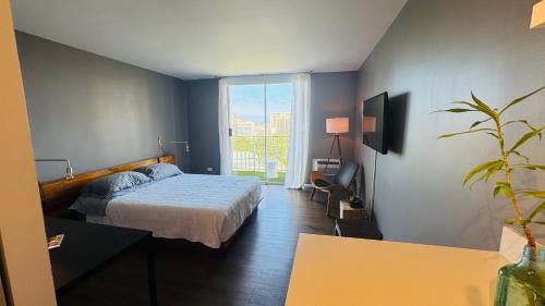 a bedroom with a bed and a large window at Inn on The Park in Honolulu