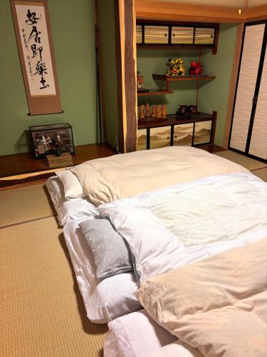 a large white bed sitting in a room with aburning at 暮らしやaizu in Kitakata