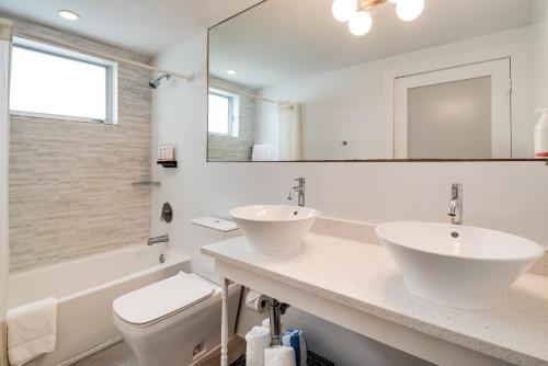 a bathroom with two sinks and a toilet and a mirror at Waterside Hotel and Suites in Miami Beach