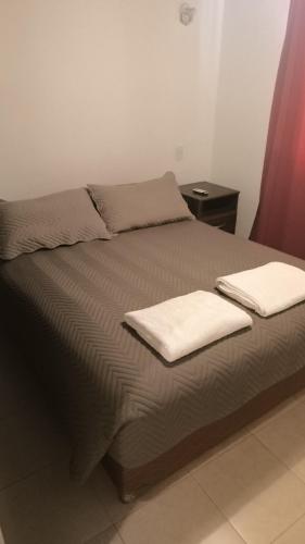 a bed with two white towels on top of it at Cafayate Deptos in Cafayate