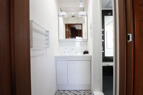 a white bathroom with a sink and a mirror at Yokohama Mega Stay in Yokohama