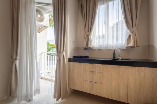 a kitchen with a sink and a window at Bali Bustle Pararaton Coliving and Coworking Space in Legian