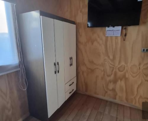 a room with a white cabinet and a flat screen tv at Los Gladiolos in Melipeuco