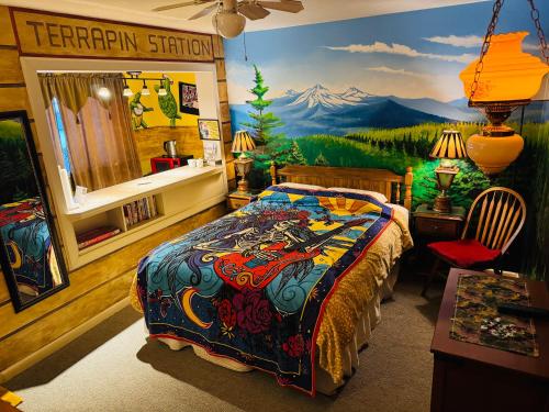 a bedroom with a mountain mural on the wall at Itty Bitty Inn in North Bend