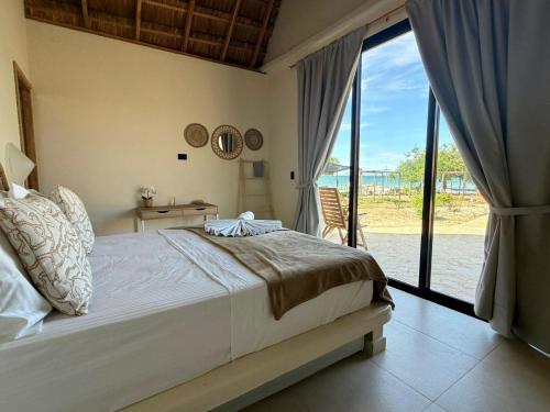 a bedroom with a large bed and a large window at Corales de Isla Fuerte in Puerto Limón