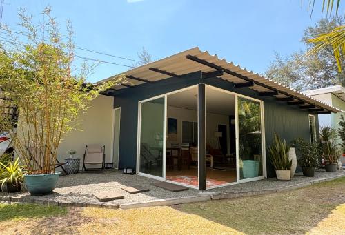 a house with a conservatory with sliding glass doors at Bamboo Beach House @ Phang Nga in Thai Muang