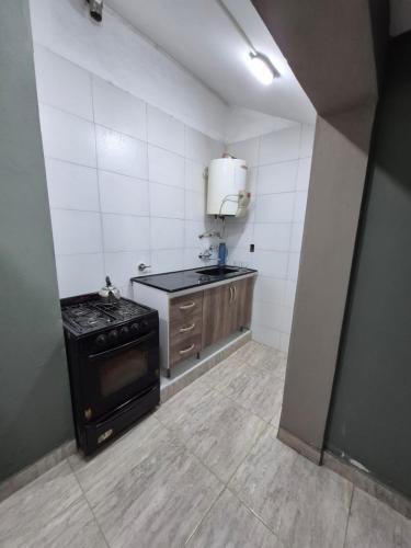 a small kitchen with a stove and a sink at Kusi 51 in La Banda
