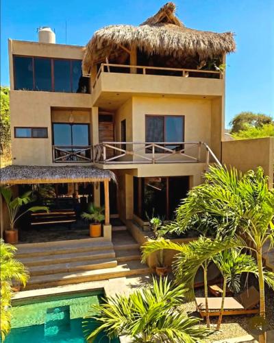 a house with a swimming pool in front of it at Casa Maloya alberca y vista al mar in Puerto Escondido