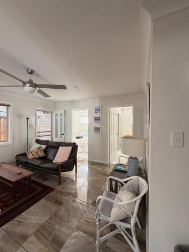 a living room with a couch and a table and chairs at Patonga Street Retreat in Patonga