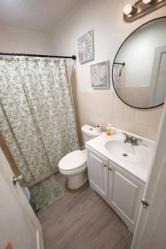 a bathroom with a toilet and a sink and a mirror at La Mare Fort Lauderdale Airport in Fort Lauderdale