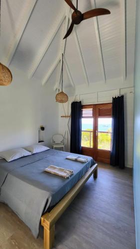 a bedroom with a bed and a ceiling fan at Villa Bois coco Les Saintes in Terre-de-Haut