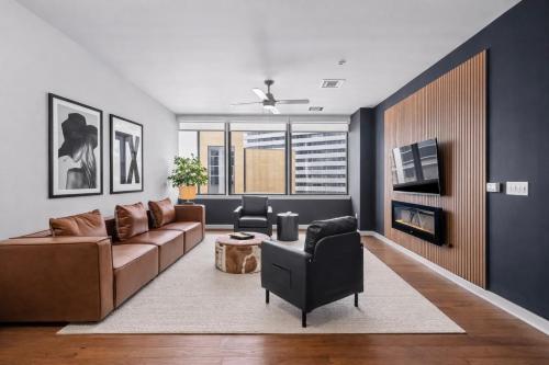 a living room with a couch and a tv at Luxury 17th Floor Downtown Dallas High-Rise with Free Parking, City Views, Pool & Gym in Dallas