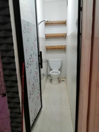 a bathroom with a toilet in a room with a door at U&R Bay View Beach Resort in Burgos