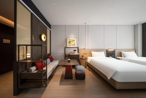 a hotel room with two beds and a table at Madison Hotel Jinan CBD in Jinan