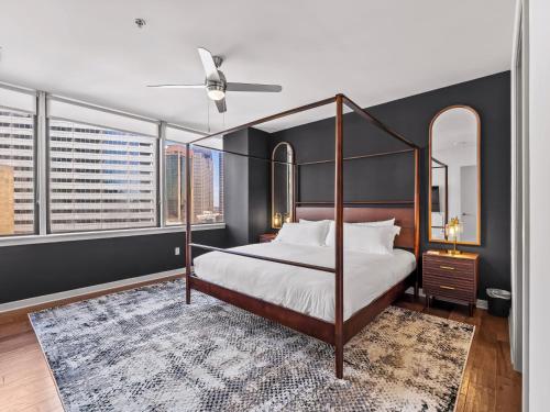 a bedroom with a canopy bed and a large window at Luxury 17th Floor Downtown Dallas High-Rise with Free Parking, City Views, Pool & Gym in Dallas