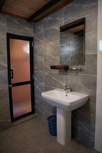 a bathroom with a sink and a mirror at Forest Edge Resort in Kitulgala