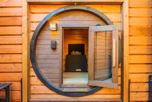 a circular window on a cabin with a table in it at P's Wood 伊豆高原 ー温泉大浴場 露天風呂 サウナ 屋根付BBQを満喫ー in Ito