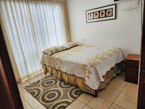 a bedroom with a bed and a large window at Casa de Campo Arenal in San Francisco