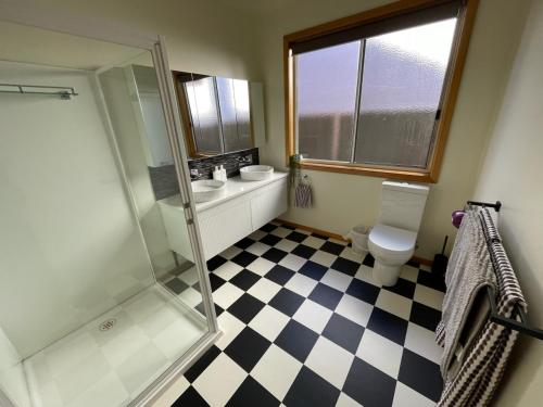 a bathroom with a shower and a sink and a toilet at House on Heron in Mildura