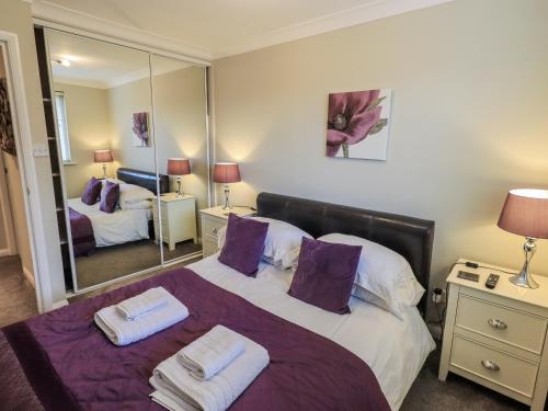 a bedroom with a large bed with towels on it at Lakeland Loft in Windermere