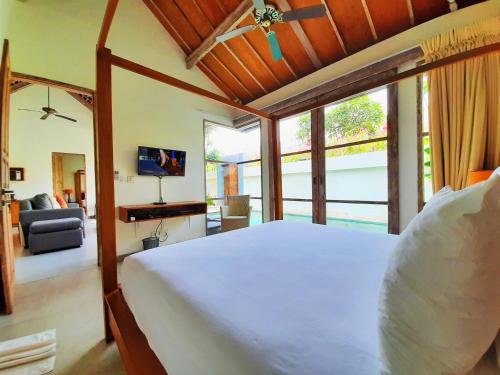 a bedroom with a large bed and a living room at The Decks Bali in Legian