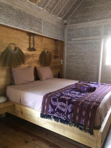 a bedroom with a bed with a wooden headboard at La Bohème in Gili Islands