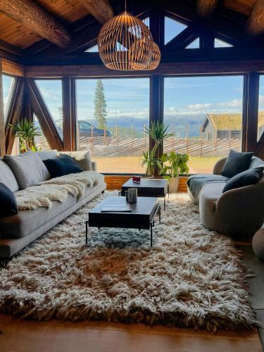 a living room with couches and a large window at Log Cabin With Views Over Turufjell in Flå