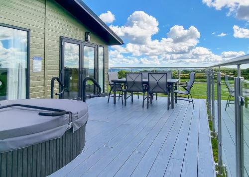 a deck with a table and chairs on a house at Woodlands Park Lodges At Haystax in Knitsley