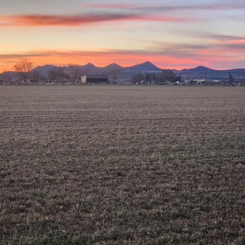 an empty field at sunset with mountains in the background at The Elevated Retreat in Cedar City