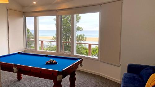 a room with a pool table in front of a window at Pelicans Perch - Scenic Coastal Retreat in Lake Tyers