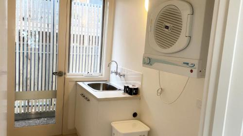 a small bathroom with a sink and a toilet at Pelicans Perch - Scenic Coastal Retreat in Lake Tyers