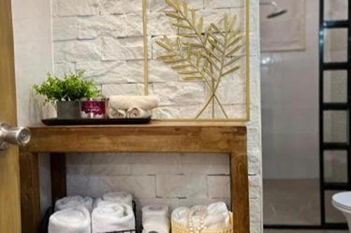 a bathroom with a pile of towels on a shelf at Hotel P INC General Santos in General Santos