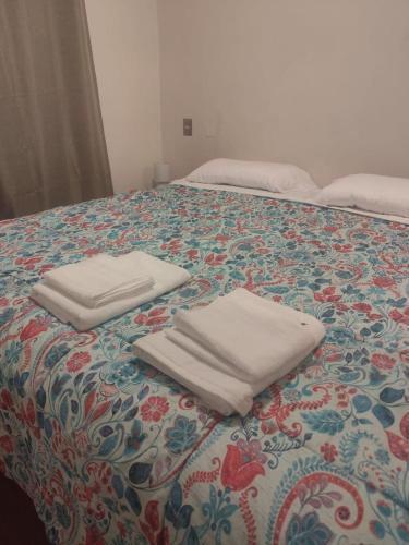 two white towels sitting on top of a bed at Valparaiso01 in Valparaíso