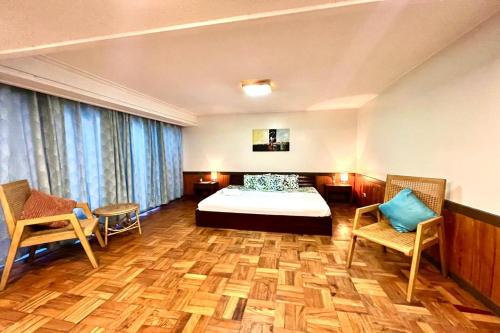 a hotel room with a bed and two chairs at Hotel P INC General Santos in General Santos