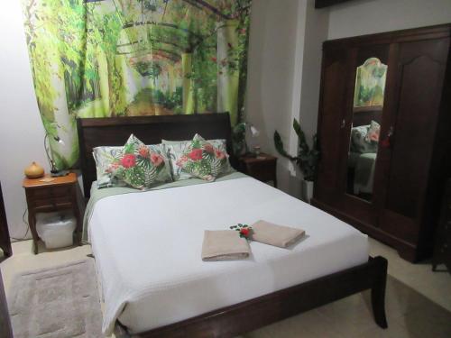 a bedroom with a white bed with flowers on it at Whitsundays Retreat in Airlie Beach