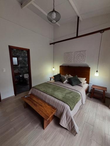 a bedroom with a large bed and a wooden table at Villa Monarca - Markinkia Estancia Amazónica in Macas