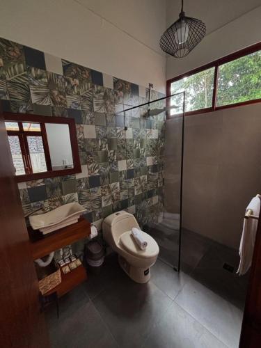 a bathroom with a shower and a toilet and a sink at Villa Monarca - Markinkia Estancia Amazónica in Macas
