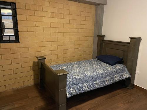a bed in a room with a brick wall at Departamento en Torre Historicah in Monterrey