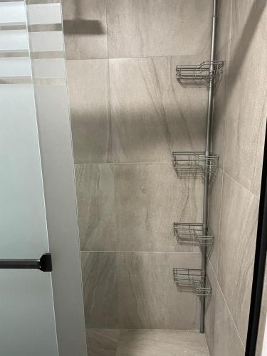 a shower with a glass door with three baskets at Departamento en Torre Historicah in Monterrey