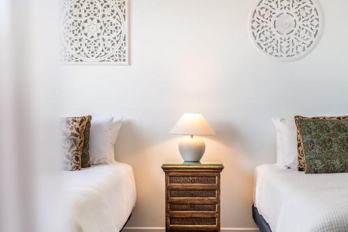 a bedroom with two beds and a table with a lamp at Sea Haven in Lennox Head