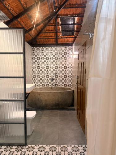 a bathroom with a tub and a toilet at Bhoomi by Ostello in Varkala