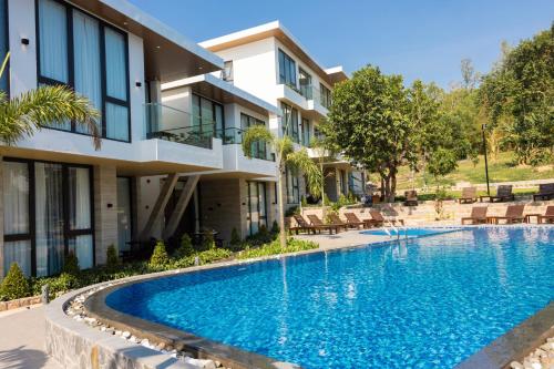 a swimming pool in front of a building at GAIA Hotel & Residence Phu Quoc in Phú Quốc